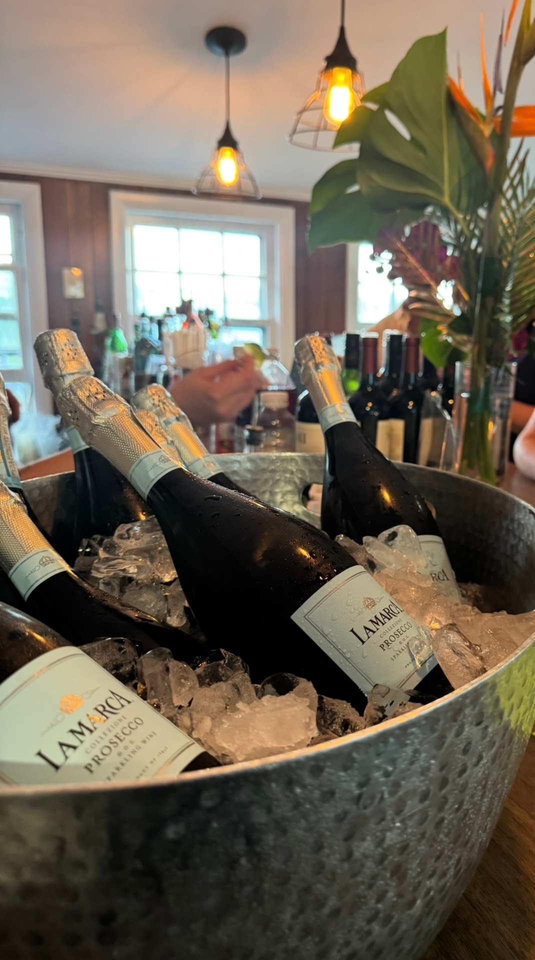 Chilled prosecco bottles on ice at a styled bar station