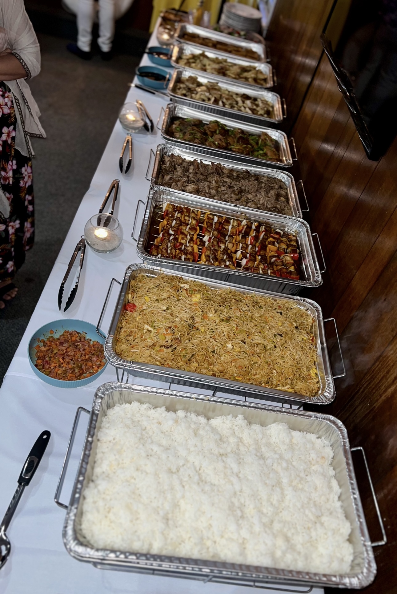 Full buffet spread with rice, noodles, skewers, and carved meats