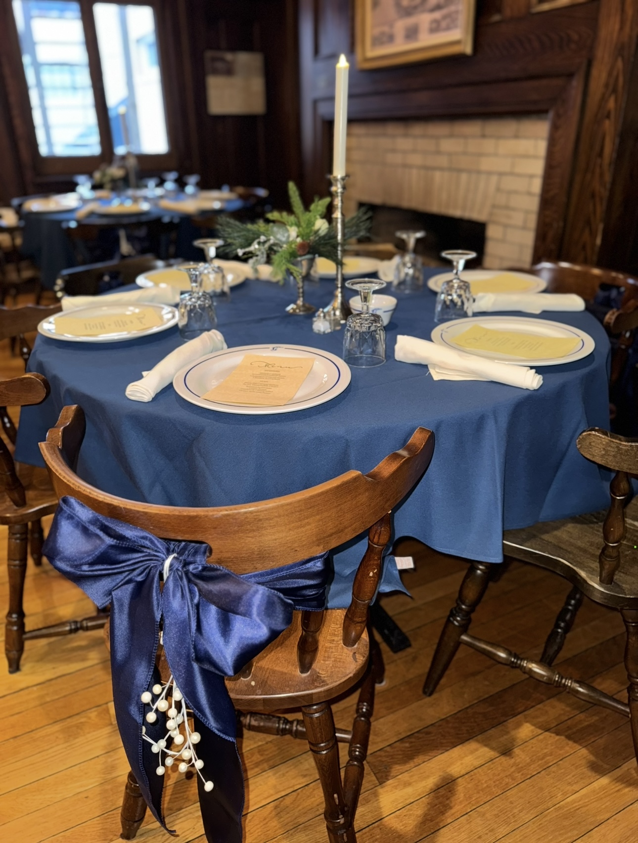 Close view of a holiday place setting beside a fireplace