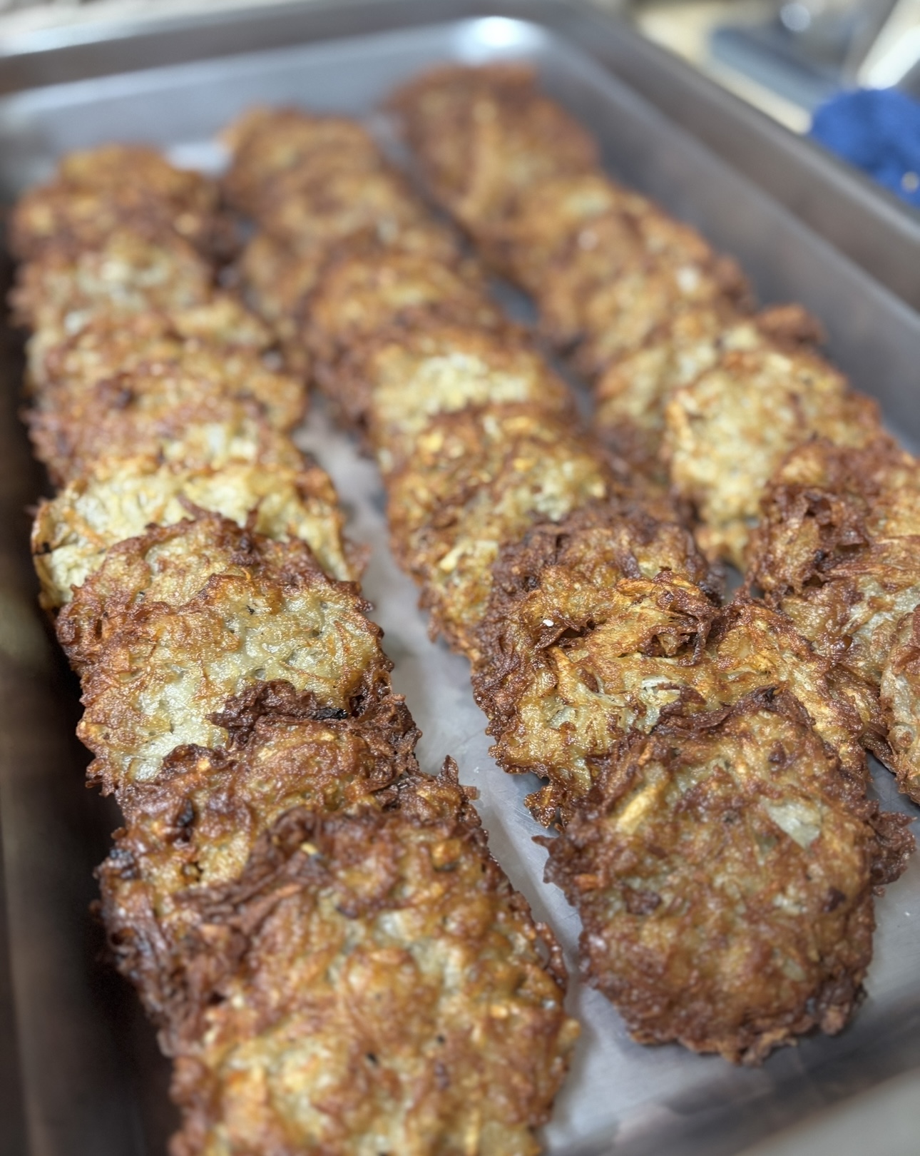 Crispy hand-fried potato latkes on a sheet tray