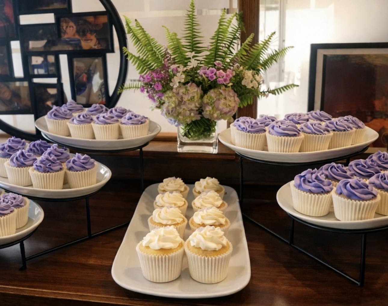 Purple and vanilla buttercream cupcakes displayed with fresh florals