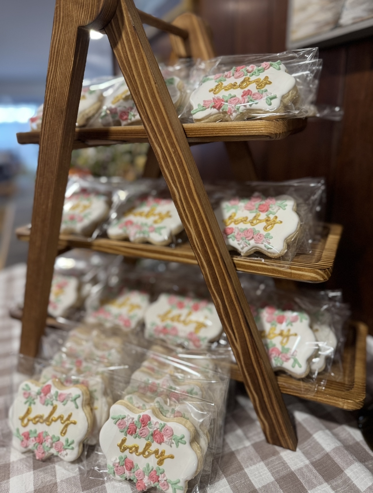 Custom decorated baby shower cookies on a wooden display