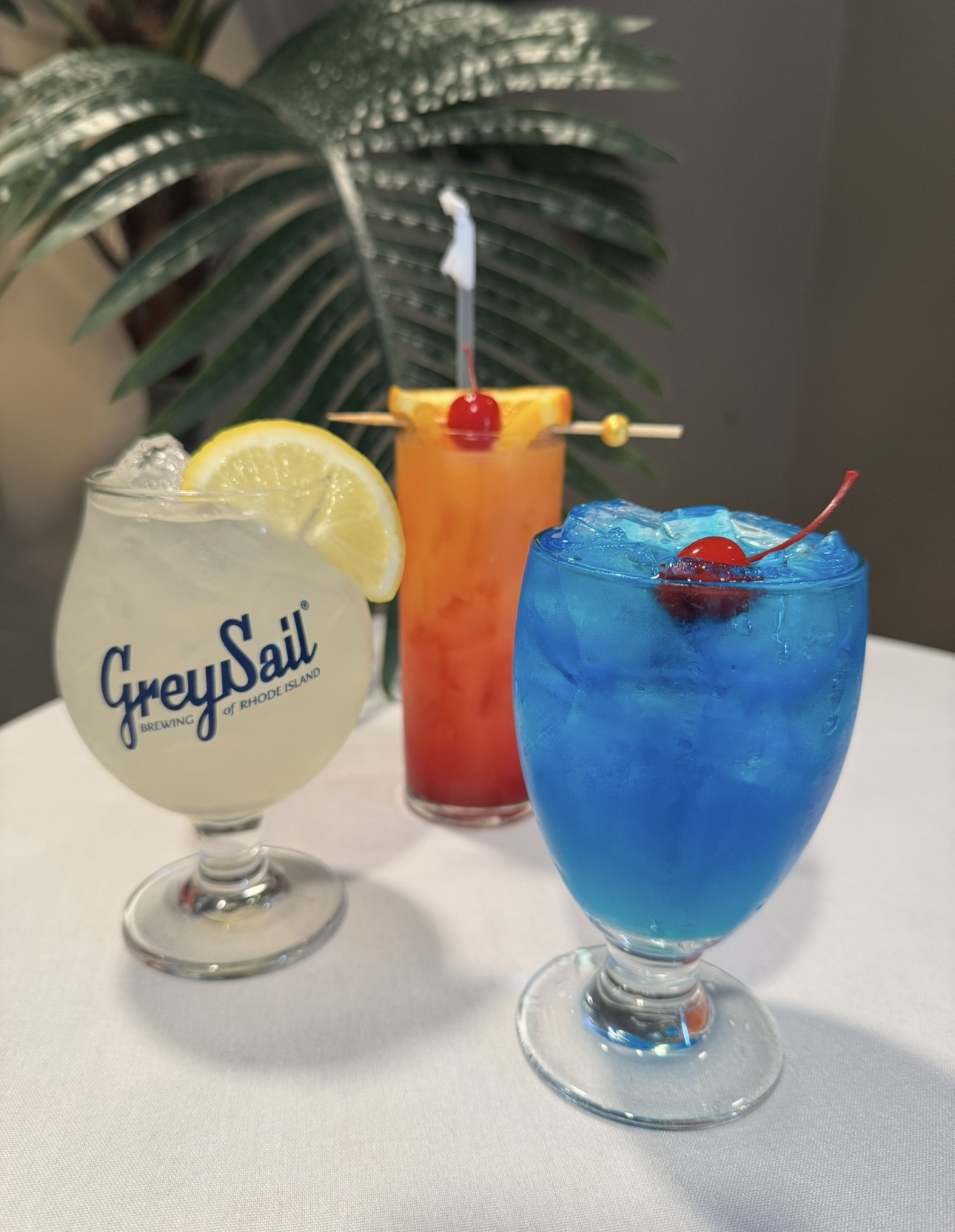 Tropical cocktail trio with Grey Sail, sunrise, and blue lagoon drinks