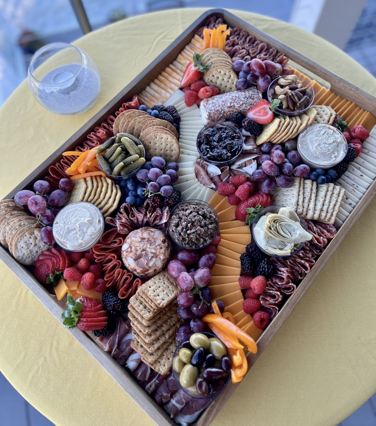 Loaded charcuterie board with cheeses, meats, fruit, and dips