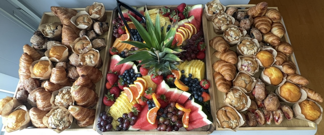 Brunch grazing board with pastries, muffins, and fresh fruit